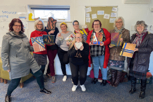 restore-hope-group A group of women holding artwork they have made.